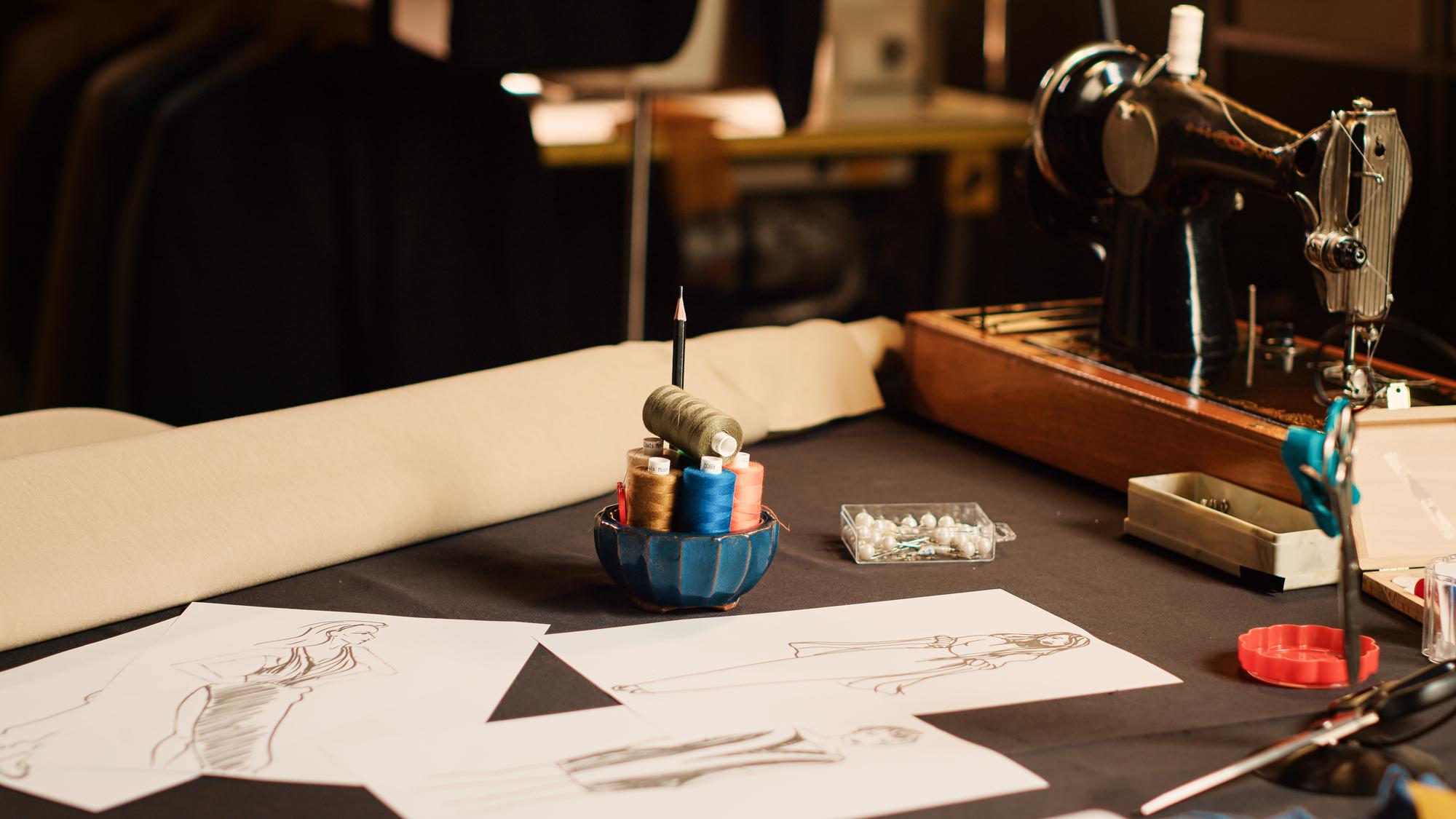 studio table with threads and sketches